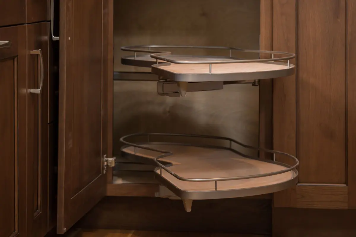 Brown revolving cabinet with pantry trays extended.