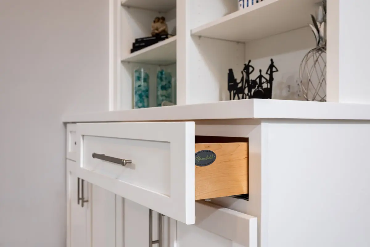 White cabinets and drawer with silver handles.